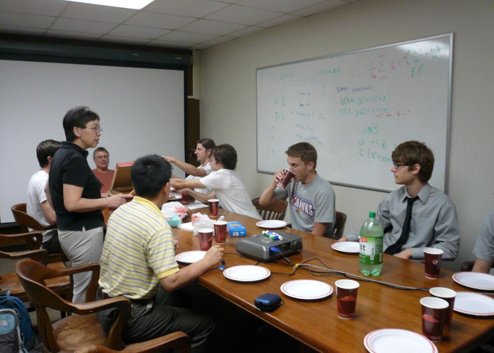 Members eating pizza at conference table