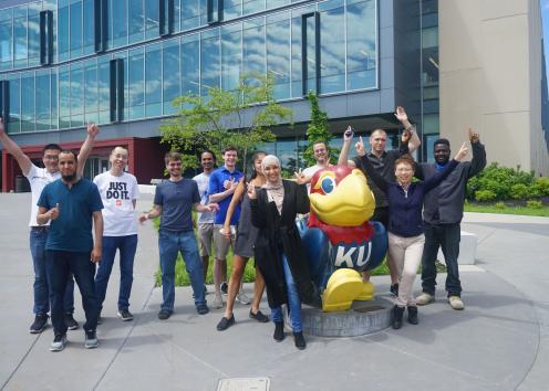 Members standing in  front of Jayhawk in front of Gray Little Hall